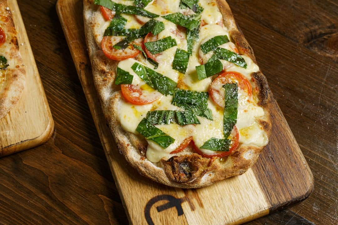 a pizza sitting on top of a wooden cutting board