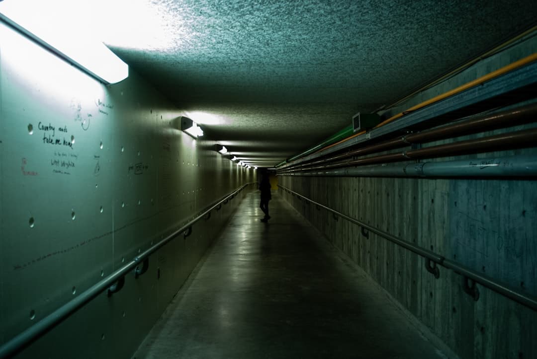 a person walking down a long dark hallway