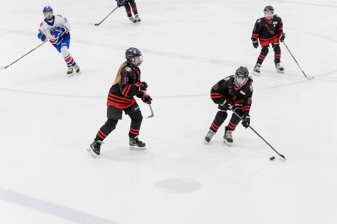 a group of young people playing a game of ice hockey