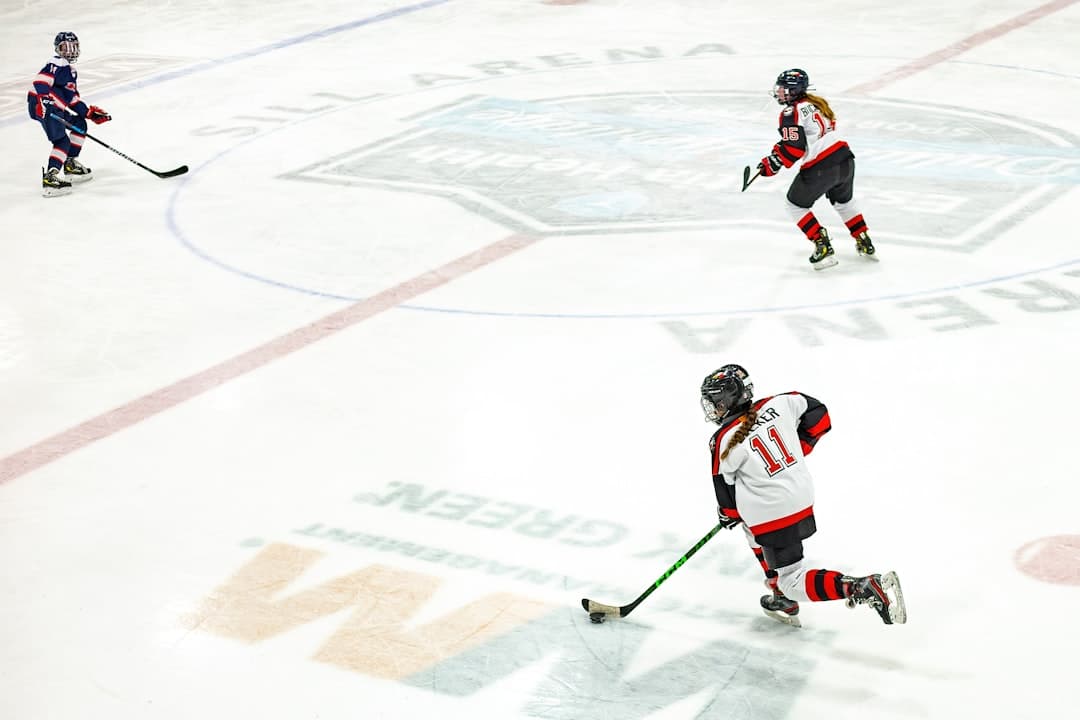 a group of people playing a game of ice hockey