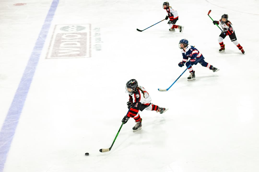 a group of young children playing a game of ice hockey