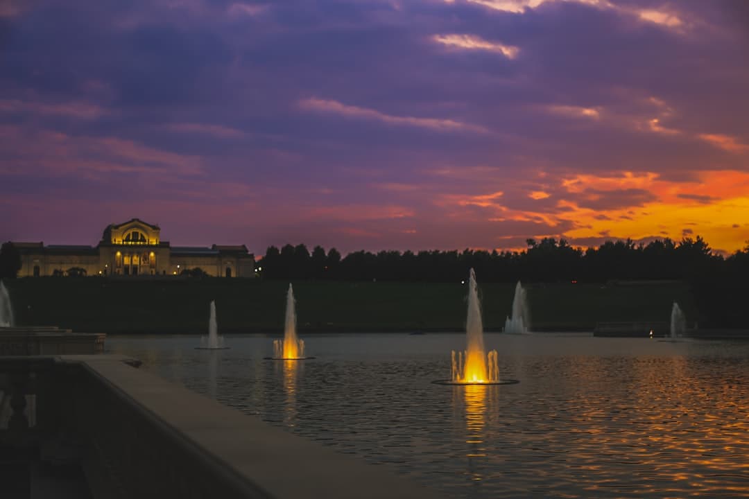 a sunset view of a building and a fountain