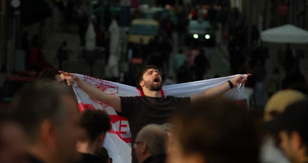 a man holding a white and red flag in a crowd