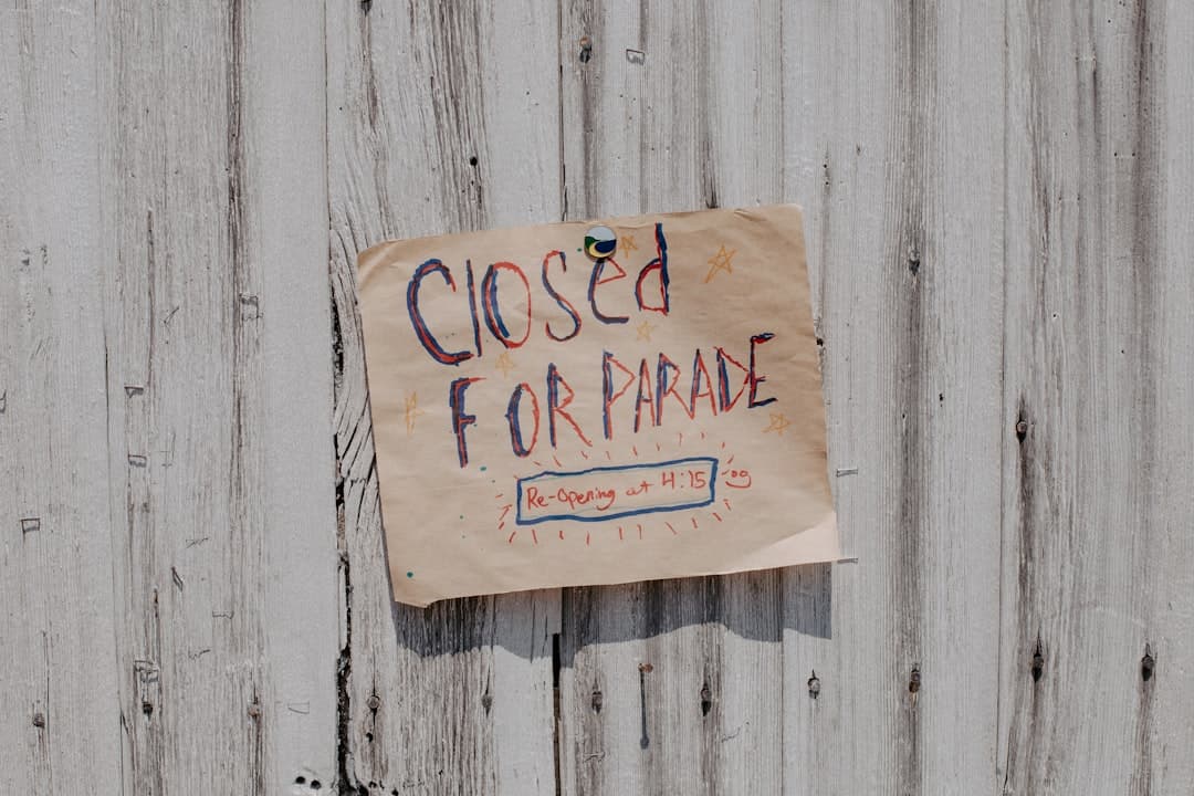 a sign posted on a wooden fence that says closed for parade