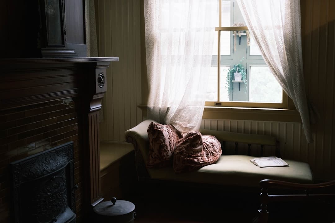 a room with a window, a chair and a book