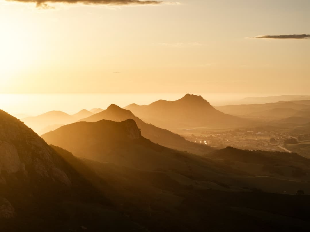 a person standing on top of a mountain at sunset