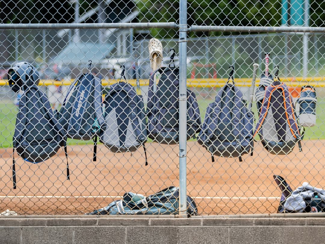 a baseball field with a bunch of clothes hanging on a chain link fence